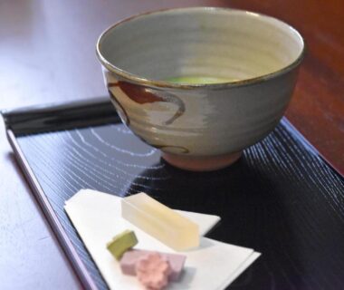 Traditional matcha bowl with wagashi sweets on a lacquer tray in a ryokan setting, Kyoto