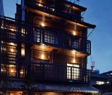 Illuminated multi-story wooden facade with balconies at Kyonoyado Kagihei in Kyoto, Kansai