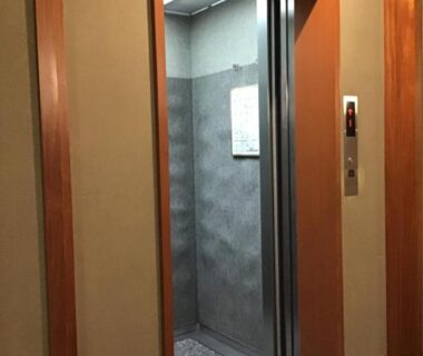 Small guest elevator with metal cabin and wood frame doorway in Kyonoyado Kagihei hallway, Kyoto
