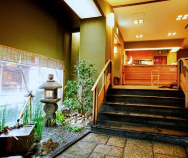 Stone lantern and tiled walkway leading to wooden step entrance of Kyoto Arashiyama Onsen Ryokan Togetsutei