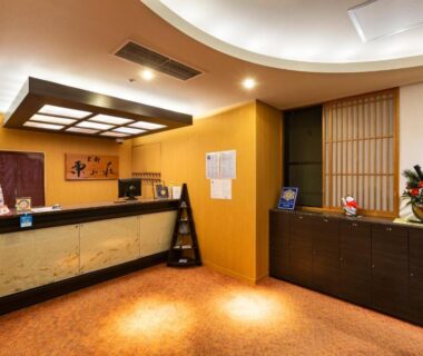 Warm ryokan reception counter with wooden cabinets, shoji screen and brochures at Kyoto Higashiyamaso