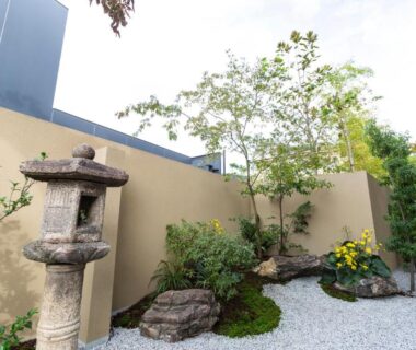 Small courtyard garden with stone lantern, white gravel, rocks and shrubs at Kyoto Higashiyamaso in Kyoto