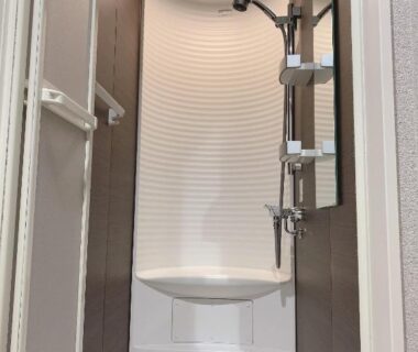 Enclosed shower stall with bench and adjustable shower head at Gion Sano Ryokan Kyoto