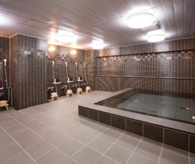 Tiled communal bathing area with stools and shower stations at Kyoto Ryokan Hirashin, Kyoto, Kansai