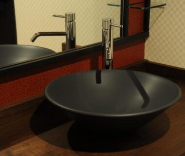 Matte black round sink on wooden counter with modern faucet and mirror at Kyoto Takasegawa Bettei, Kyoto
