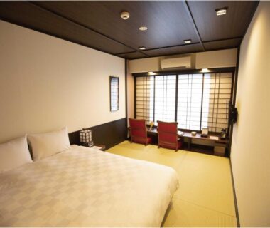 Tatami room with western bed, shoji screens and low seating at Kyoto Takasegawa Bettei in Kyoto, Kansai