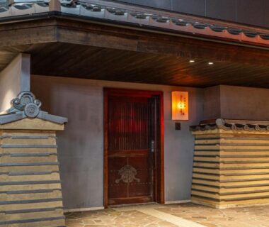 Wooden entrance door with lit lanterns at Kyoto no Yado Gion no Tsuki, Kyoto exterior