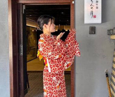Guest in red kimono standing at Kyoto no Yado Gion no Tsuki entrance Kyoto