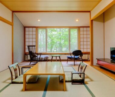 Traditional tatami room with low table, shoji screens and forest-view window at Kyukamura Nikko-Yumoto, Tochigi
