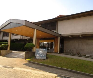 Covered entrance with signboard at Kyukamura Noto-Chirihama, low two-story building in Ishikawa Chūbu