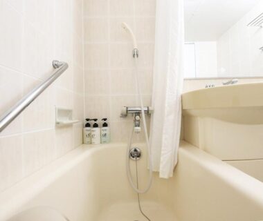 Compact tiled bathroom in Kyukamura Ura-Bandai, Fukushima with bathtub, shower and toiletries