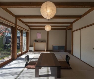 Spacious tatami room with low wooden table, shoji screens and garden view at Kyutei, Kumamoto