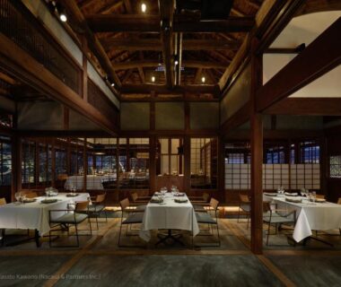 Spacious wooden dining room with white-clothed tables and exposed beams at LOQUAT西伊豆 in Shizuoka
