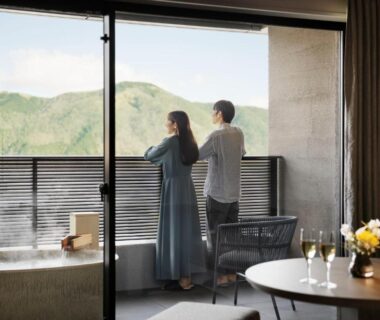 Couple on balcony beside steaming stone tub at Laforet Hakone Gora Yunosumika, Kanagawa mountains
