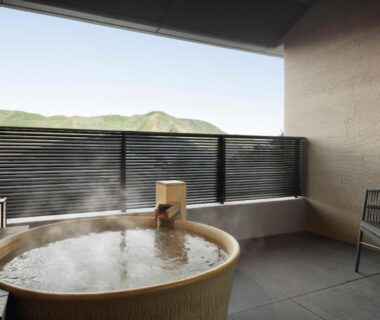 Steaming round soaking tub on balcony with mountain view and chair at Laforet Hakone Gora Yunosumika Kanagawa