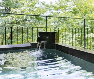 Outdoor stone onsen bath with wooden bucket at Laforet Shuzenji Sanshisuimei, Shizuoka, Chūbu