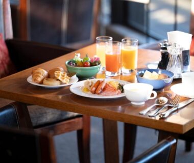 Breakfast spread with croissants, juice and coffee on wooden table at Laforet Shuzenji Sanshisuimei in Shizuoka, Chūbu, Japan