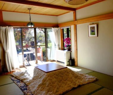 Tatami room with kotatsu and sliding doors opening to garden at Lake Oshino, Yamanashi
