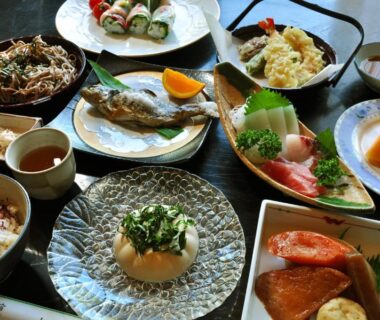 Assorted small plates including grilled fish, sashimi, tempura, rice and fruit, ryokan meal at Lake Oshino, Yamanashi