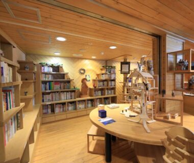Warm wooden reading room with bookshelves and round table at Lake Saroma Tsuruga Resort, Hokkaidō