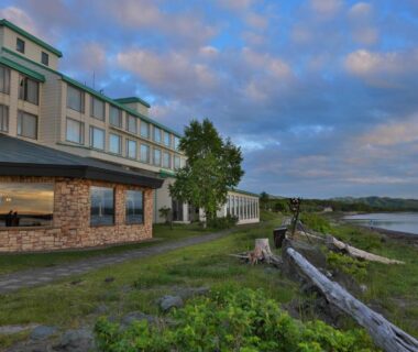 Lakeshore with resort building and grassy foreground, Lake Saroma Tsuruga Resort, Hokkaidō, Japan