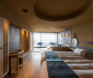 Contemporary twin room with two beds, wooden floor, seating area and lake view at Lake Shikotsu