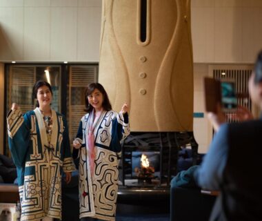 Two guests in patterned robes by fireplace in the lounge at Lake Shikotsu Tsuruga Bessou AO no ZA, Hokkaidō