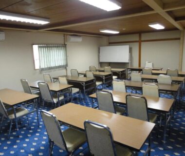 Rows of tables and chairs, whiteboard and blue patterned carpet at Lake Side Hotel Minatoya, Fukushima