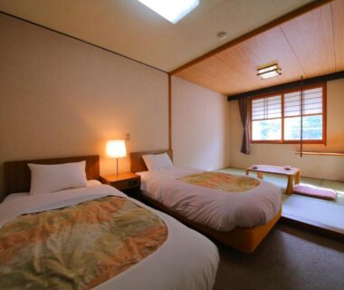 Twin beds with raised tatami alcove, low table and wooden-framed window at Lake Side Hotel Minatoya Fukushima Tōhoku