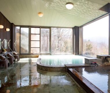 Spacious indoor communal onsen with central tub and wash stations at Lake Side Nikko in Tochigi
