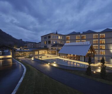 Lit resort exterior with water feature and mountain backdrop at dusk, Lake Toya Tsuruga Resort HIKARINOUTA, Hokkaidō