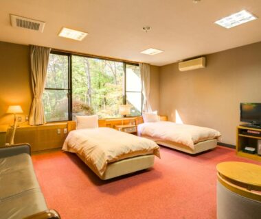 Carpeted twin room with sofa, TV and garden view at Lake Yamanakako Shuzansou, Yamanashi, Chūbu, Japan