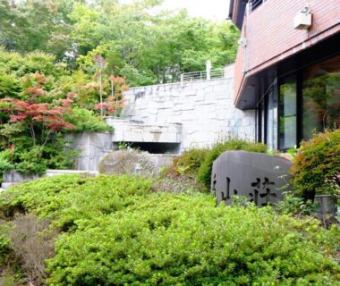 Lush entrance garden with stone name plaque at Lake Yamanakako Shuzansou in Yamanashi