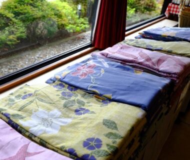 Folded guest robes on window bench with cushions, view of garden outside at Lake Yamanakako Shuzansou Yamanashi