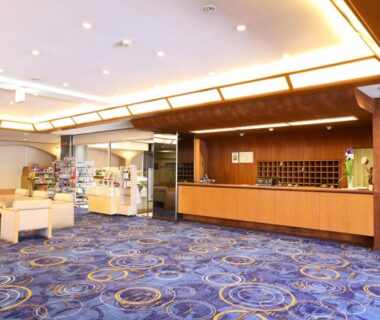 Carpeted hotel lobby with reception desk, seating area and gift shop at Lakeland Hotel Mizunosato Yamanashi Chūbu Japan