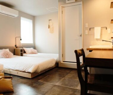 Twin beds on low platforms with desk and window in Lampstand STAY Asahikawa Hokkaidō room