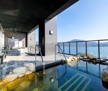 Outdoor onsen terrace at LiVEMAX RESORT Aki Miyahama Onsen overlooking a coastal bay in Hiroshima, Chūgoku, Japan