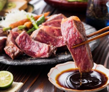 Sliced grilled beef dipped in sauce with chopsticks at LiVEMAX RESORT Hakone Ashinoko, Kanagawa