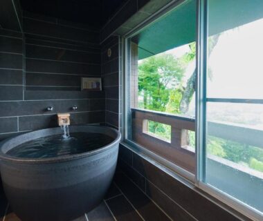 Indoor stone soaking tub by sliding windows at LiVEMAX RESORT Hakone Sengokuhara, Kanagawa