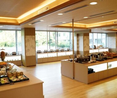 Bright buffet dining area with serving stations and large windows at LiVEMAX RESORT Kaga Yamashiro in Ishikawa