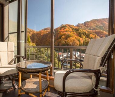 Balcony chairs and table overlooking autumn forested hills at LiVEMAX RESORT Kawaji Tochigi