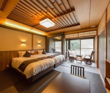 Twin beds on tatami platform with shoji screens, low table and balcony overlooking trees at LiVEMAX RESORT Kawaji, Tochigi