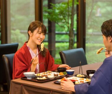 Guests in yukata enjoying a traditional meal by window overlooking garden at LiVEMAX RESORT Kinugawa Tochigi
