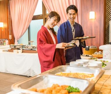 Guests in yukata selecting dishes at ryokan buffet table inside LiVEMAX RESORT Kinugawa, Tochigi