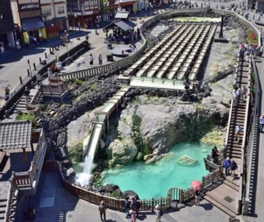 Turquoise hot spring basin with wooden walkways near LiVEMAX RESORT Kusatsu Onsen, Gunma