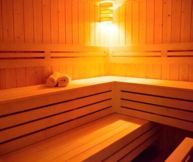 Interior wooden sauna with tiered benches, warm lighting and folded towels at LiVEMAX RESORT Kyotango, Kyoto