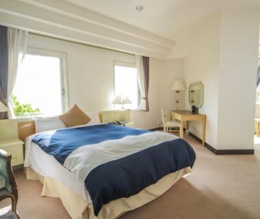 Sunlit Western-style room with double bed, desk, armchair and large windows at LiVEMAX RESORT Setouchi Sea Front in Hyōgo