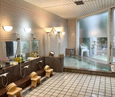 Indoor communal bathing area with stools, mirrors, and tiled soaking pool at LiVEMAX RESORT Setouchi Sea Front Hyōgo Japan