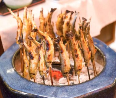 Skewered fish grilling over charcoal at LiVEMAX RESORT Shizuoka Amagiyugashima, Shizuoka prefecture