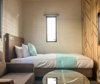 Modern room with bed, sofa and glass table at Livemax Resort Yuhigaura Kitu Onsen, Kyoto region